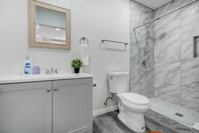 Bathroom with a grey vanity and a marble-look shower