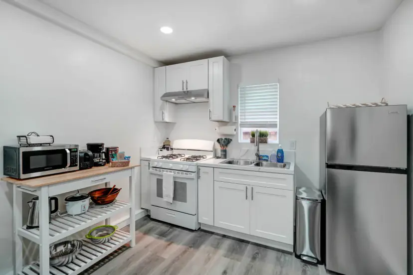 Kitchen wall with a range, a microwave and a fridge