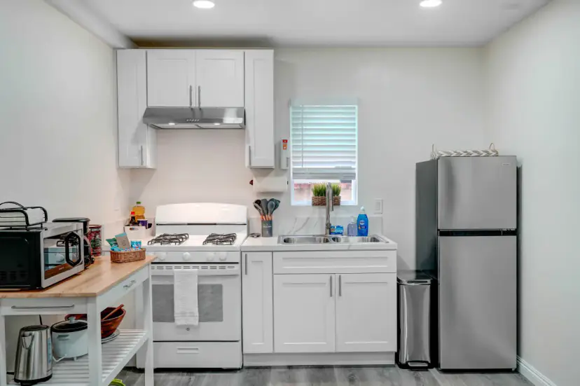 White kitchen with a stainless fridge