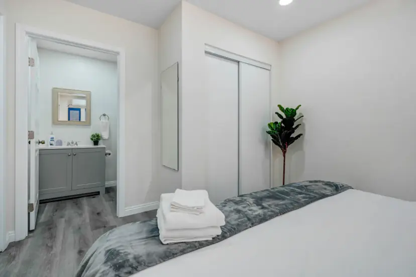 Bedroom with a sliding closet and the bathroom beyond