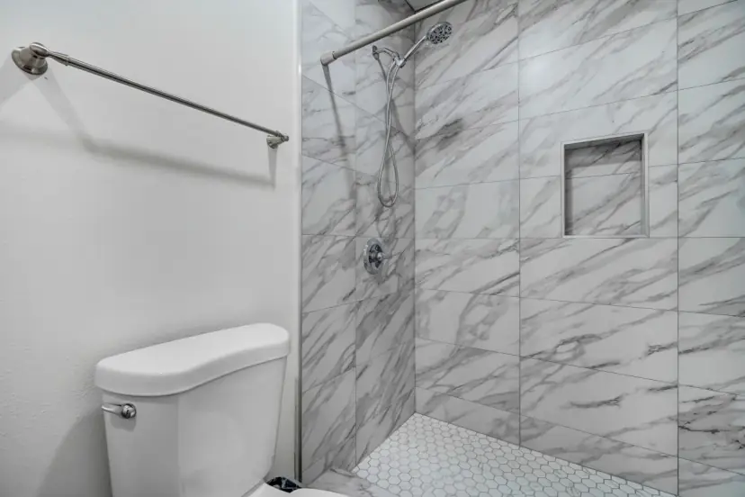 Marble-look tile shower with a niche